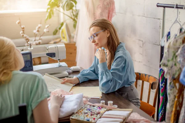 居心地の良いスタジオでクライアントの順序の機能を議論する女性女性の裁縫師 — ストック写真