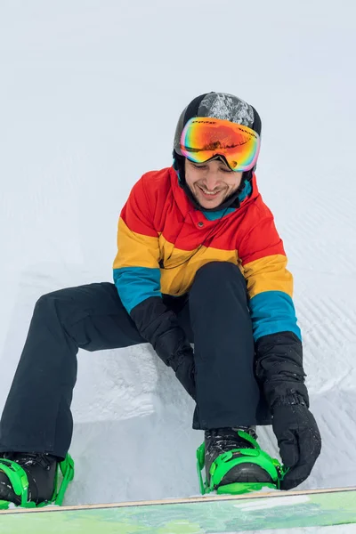 Iyi görünümlü adam snowboard için çizme koyarak sahiptir — Stok fotoğraf