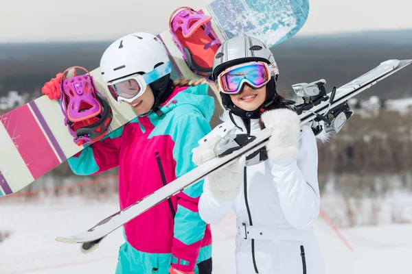 Active girls preparing for snowboarding and skiing championship — Stock Photo, Image