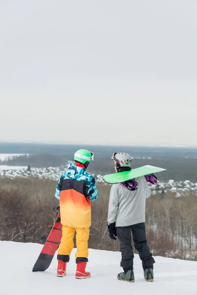 Dos deportistas activos explorando la montaña para practicar snowboard —  Fotos de Stock