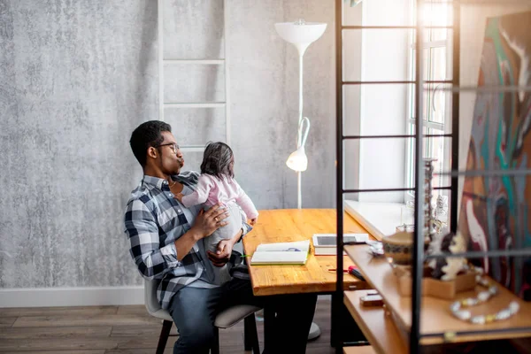 Joven guapo padre besos bebé gurl mientras sentado en el dormitorio — Foto de Stock