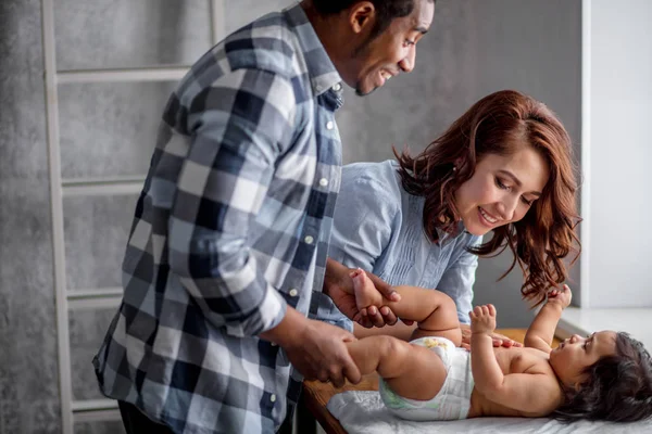 Cheerful daddy and mommy massaging the babys body — Stock Photo, Image
