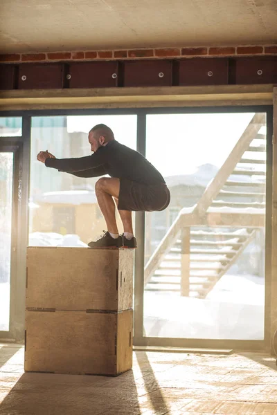 Caucásico atlético hombre realizando plyo box salto ejercicio durante crossfit entrenamiento — Foto de Stock