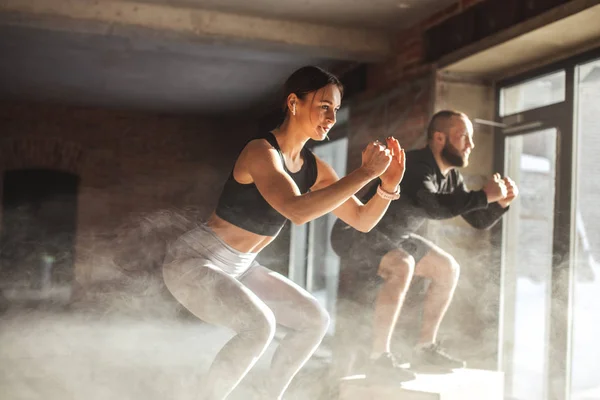 Uomo e donna che saltano tohether su scatole in palestra, allenamento funzionale per le persone — Foto Stock