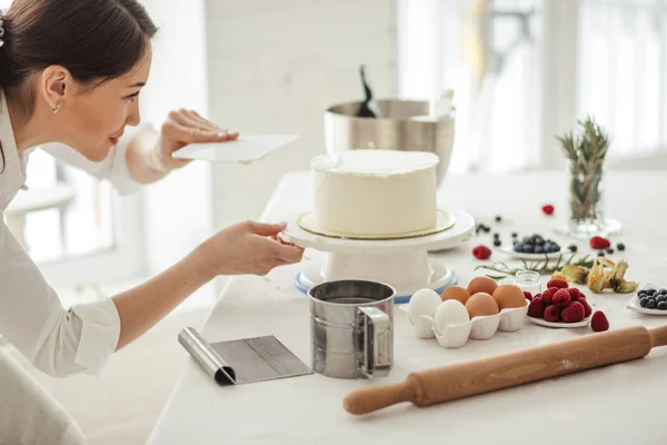 Attractive girl giving a shape to cake — Stock Photo, Image