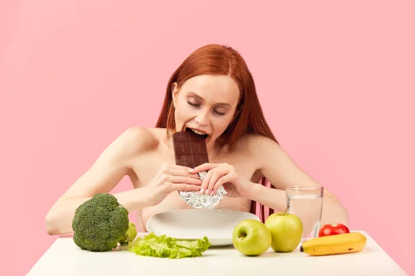 Anorexi donna si sente felice mentre mangia cioccolato invece di verdure sane. — Foto Stock