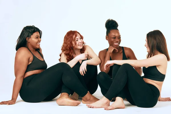 Multiracial females with different size and ethnicity stand together and smile. — Stock Photo, Image