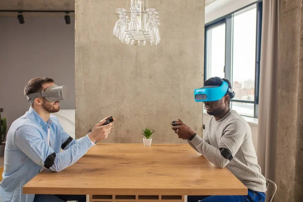 Dos hombres diversos en ropa casual están desarrollando un proyecto usando gafas de realidad virtual . —  Fotos de Stock