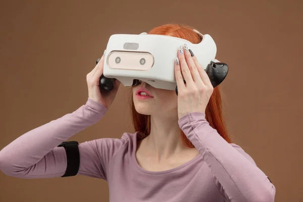 Χαρούμενος νεαρός Κοκκινομάλλης γυναίκα χρησιμοποιώντας μια κάσκα εικονικής πραγματικότητας — Φωτογραφία Αρχείου