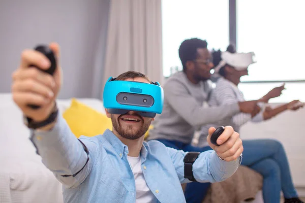 Multiracial group of friends having fun trying on 3D virtual reality goggles.