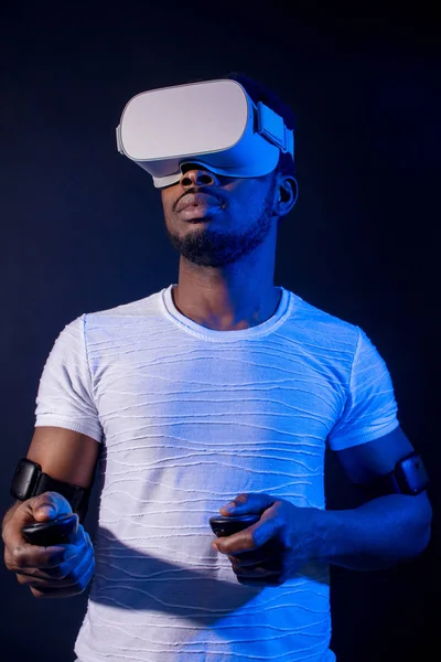 African Man in white, wearing VR Headset on green blue dual color background.