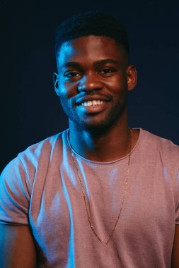 Afrikalı heyecanlı genç adam gülümsüyor, kamera da eğleniyor. Pozitif insan duygu.