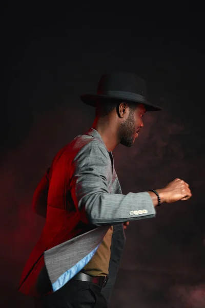 Homem músico de jazz preto vestindo terno elegante e chapéu cinza em movimento — Fotografia de Stock