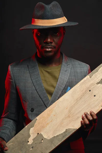 Joven empresario africano guapo con longboard en la oficina — Foto de Stock