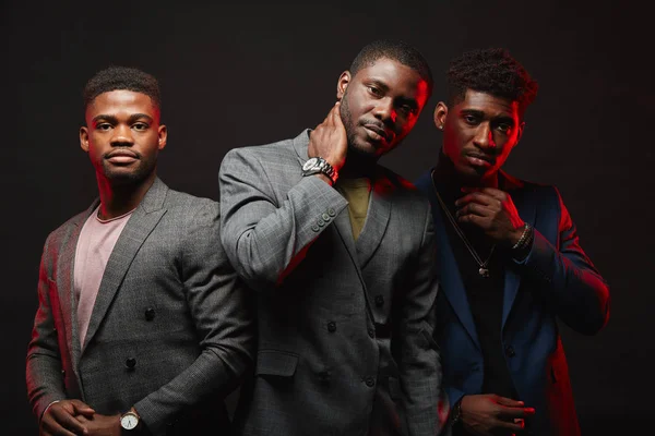 Grupa trzech czarnych mężczyzn w stylowych garniturach stwarzających odizolowane w Studio — Zdjęcie stockowe