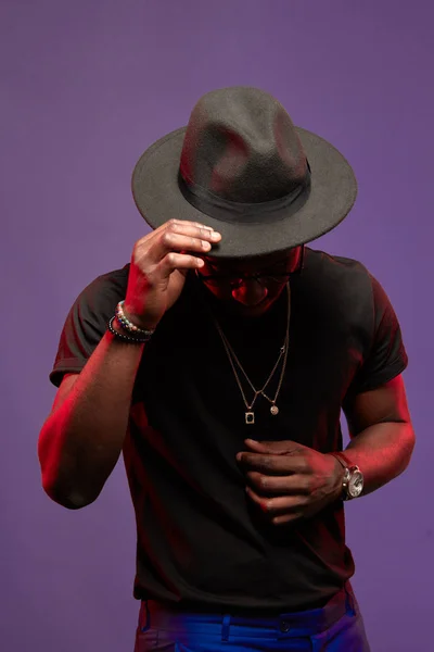 DJ africano ou músico de jazz de chapéu e t-shirt preta sobre fundo roxo — Fotografia de Stock