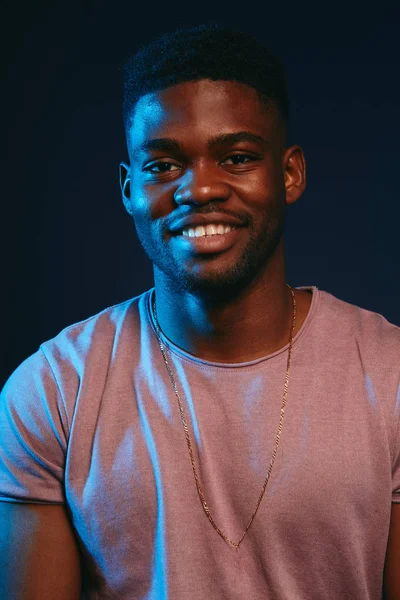 Afrikanischer aufgeregter junger Mann lächelt und amüsiert sich vor der Kamera. Positive menschliche Emotion. — Stockfoto