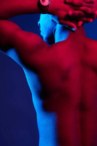 Rückansicht eines afrikanischen männlichen Athleten mit nacktem Rücken, der gegen eine dunkle Wand posiert. — Stockfoto