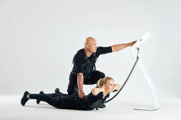 Mann hält eine Frau zurück und drückt den Knopf des ems-Geräts — Stockfoto