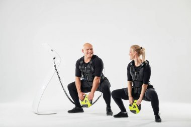 pozitif genç çift bir ağırlık tutarken squats yapıyor