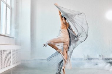 Beyaz kumaşlı kadın balerin. Şekiller ve hareket.