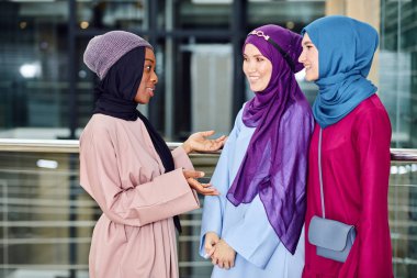 Ulusal giysiler içinde grup halinde poz veren çok ırklı Müslüman kadınlar.