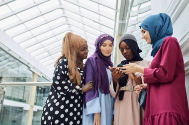 Arabistanlı genç kadinlar cep telefonundan video klip izliyorlar..