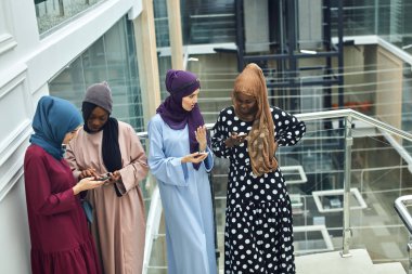 Arabistanlı genç kadinlar cep telefonundan video klip izliyorlar..