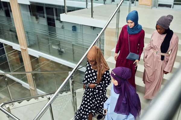 Grupo de cuatro chicas musulmanas caminando por las escaleras del centro comercial — Foto de Stock