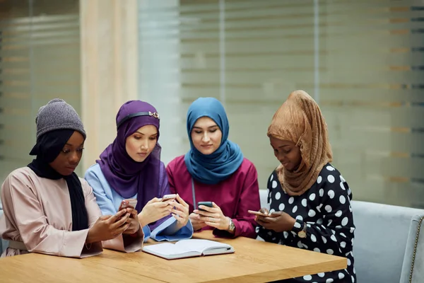 Mujeres islámicas asiáticas compartiendo información desde un smartphone durante su visita a un seminario — Foto de Stock