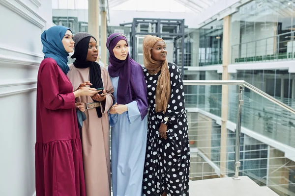 Grupo multiétnico musulmán de chicas mira el teléfono inteligente en la mano de la mujer africana — Foto de Stock