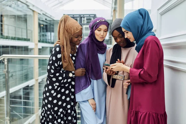 Mujeres islámicas asiáticas compartiendo información desde un smartphone durante su visita a un seminario —  Fotos de Stock
