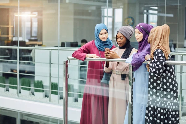 Pareja joven negocio musulmán femenino utilizando el contacto de teléfono inteligente con el socio — Foto de Stock