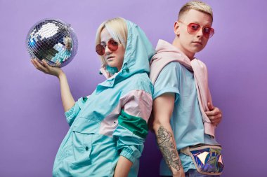 Mor arka planda disko topuyla poz veren genç moda dansçıları.