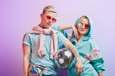 Mor arka planda disko topuyla poz veren genç moda dansçıları.