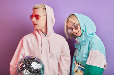 Mor arka planda disko topuyla poz veren genç moda dansçıları.