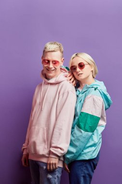 Mor arka planda disko topuyla poz veren genç moda dansçıları.