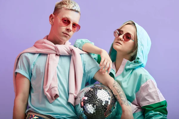 Mor arka planda disko topuyla poz veren genç moda dansçıları.