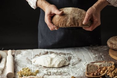 Tanınmayan baker taze pişmiş rustik organik somun ekmek elinde tutan