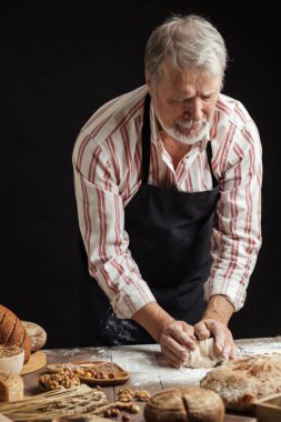 Olgun baker adam masada ekmek hamur yoğurma sakallı