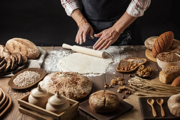 Stock image Man rolling out dough on kitchen table, close up