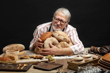 Kameraya bakarak ve somun ekmek sarılma gülümseyen mutlu eski baker