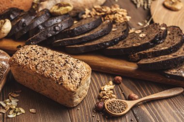 Bütün tahıl buğday ekmeği, bütün ve dilimlenmiş, siyahta izole tohum içerir