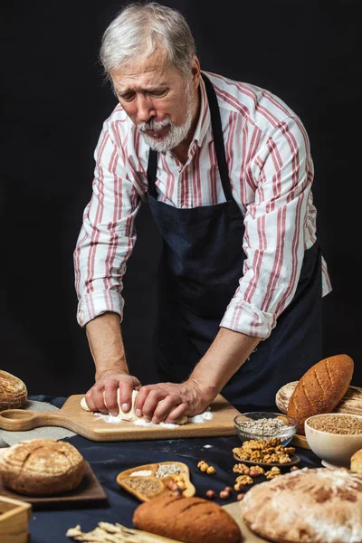 Olgun baker adam masada ekmek hamur yoğurma sakallı