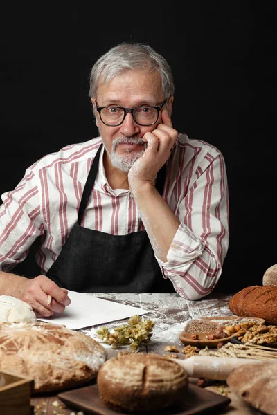 Anciano demostrando surtido de panadería. Pasteles caseros, estilo rural — Foto de Stock