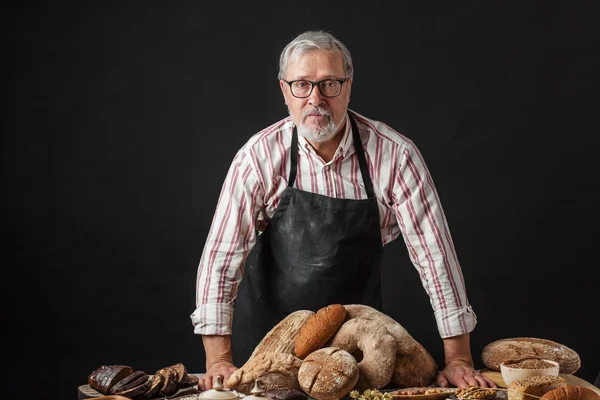 Anciano demostrando surtido de panadería. Pasteles caseros, estilo rural — Foto de Stock