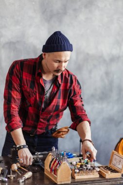 hırslı adam atölyede araçlarını sayma
