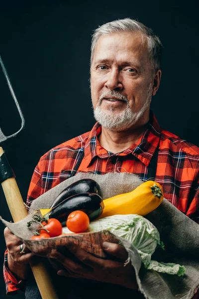 Satisfecho hombre está sosteniendo verduras y tenedor y posando a la cámara — Foto de Stock