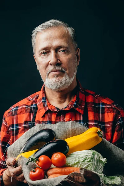 Impresionante hombre barbudo ha recogido verduras de la cama gardern — Foto de Stock