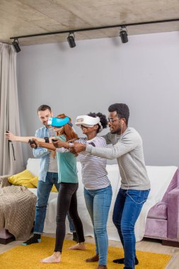 Çok kültürlü bir grup arkadaşıyla birlikte sanal gerçeklik gözlükle oyun oynamak.